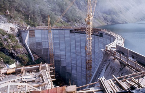 Zakariasdammen under utbygning, med to kraner foran dammen mens de bygger ferdig toppen
