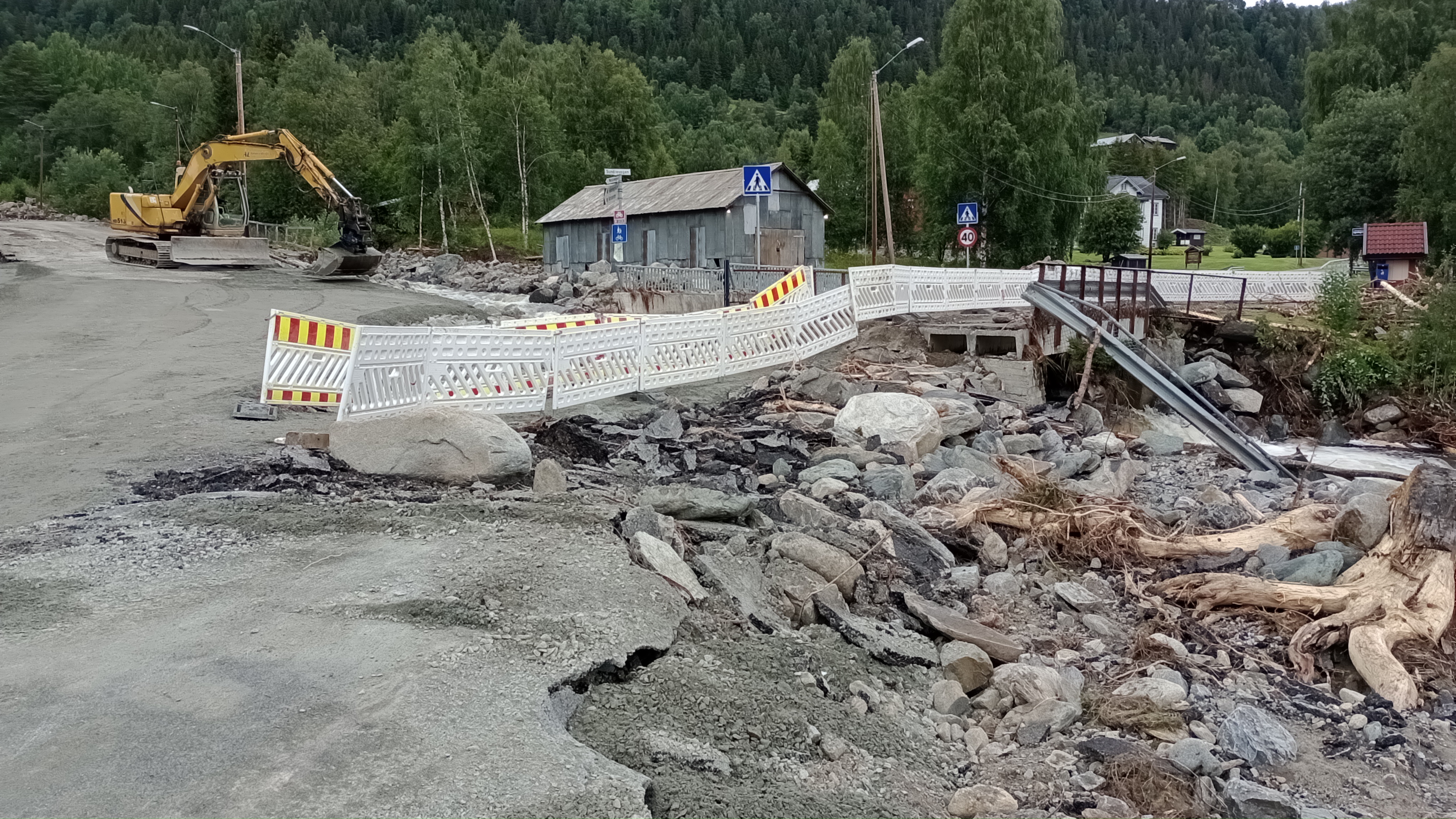 Under ekstremværet Hans ble elveløpet i nedre del av Kvinda ødelagt. Et skred førte med seg store steinmasser, trær og annet materiale. Foto: NVE